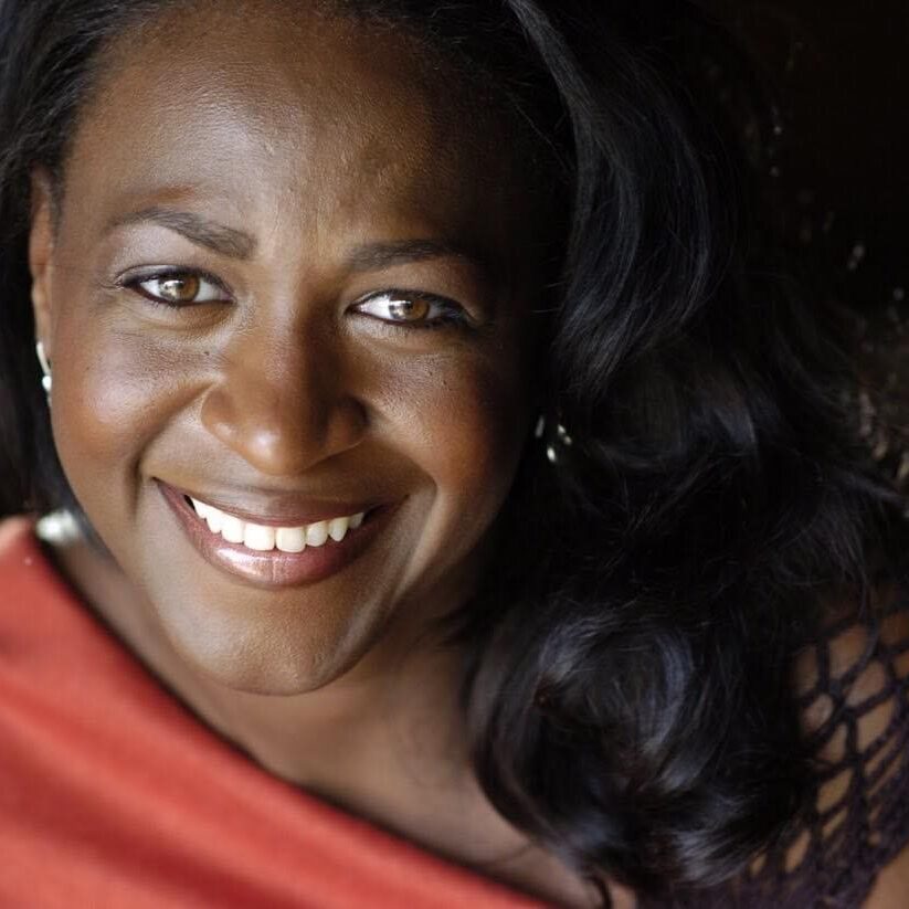 A woman with long black hair smiling for the camera.